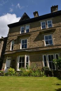 a large brick house with windows on a lawn at Glendon Bed and Breakfast in Matlock