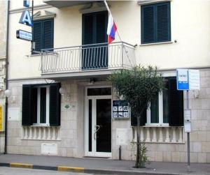 a building with a balcony and a flag on it at Hotel Astoria in Viareggio