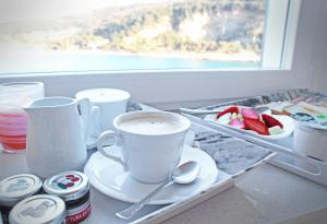 a tray with a cup of coffee and a plate of fruit at L'Ancora in Portovenere