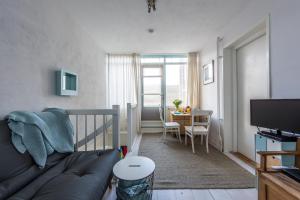 a living room with a couch and a dining room table at de Vloedlijn in Callantsoog