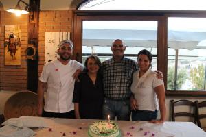a group of people standing in front of a table with a cake at Agriturismo Su Recreu in Ittiri