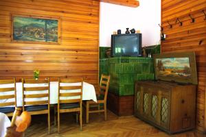 a dining room with a table and a tv at Rooms Pevc & Hostel Ljubno ob Savinji in Ljubno
