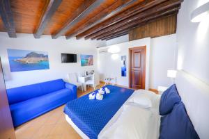 ein Wohnzimmer mit einem blauen Sofa und einem blauen Bett in der Unterkunft Cefalu in Blu in Cefalú
