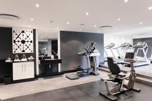 a gym with treadmills and exercise equipment in a room at The Maslow Hotel, Sandton in Johannesburg