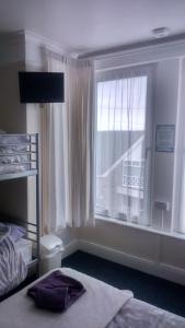 ニューキーにあるSmugglers Restのベッドルーム1室(ベッド1台付)、窓、バルコニーが備わります。