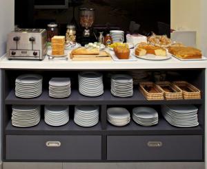 a shelf filled with plates and cakes and pastries at Hotel Vila da Guarda in A Guarda
