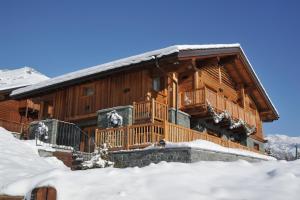 una baita di tronchi nella neve con neve di Gresil Residence a Champoluc