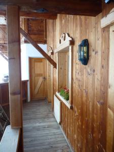 a hallway of a cabin with a wooden floor and a door at Conny's Ferienwohnungen in Gschnitz