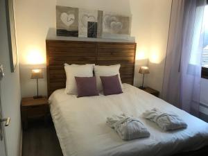 a white bed with two pillows on top of it at Pilatre de Rosier proximité plage in Wimereux