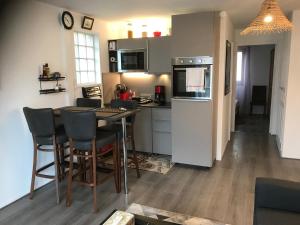 a kitchen with a table and chairs in a room at Pilatre de Rosier proximité plage in Wimereux