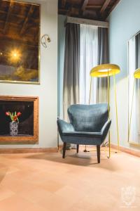 a blue chair in a room with a fireplace at Residenza Spada in Rome