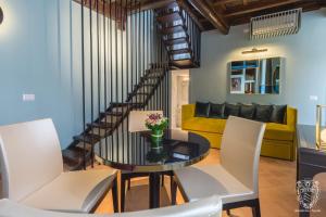 a living room with a glass table and white chairs at Residenza Spada in Rome