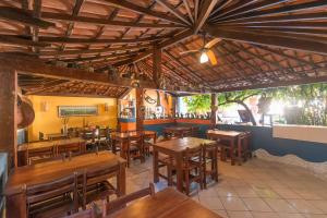 a restaurant with wooden tables and wooden chairs at Pousada Bemvirá in Arraial d'Ajuda