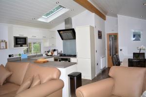 a kitchen and living room with white walls and a skylight at Ein Yfory in Benllech
