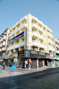a large building on a city street with a store at Deema Hotel in Dubai