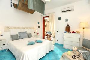 una camera con letto bianco e pavimenti piastrellati blu di Mirtillo by Amalfivacation a Minori