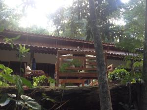 a house with a table and chairs in a garden at Entre Arvores Refúgio in Lumiar