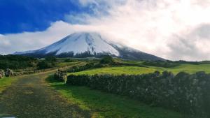 una montaña en un campo verde con un camino de tierra en Casa do Paim, en São Roque do Pico