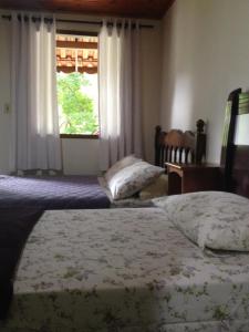 - 2 lits dans une chambre avec fenêtre dans l'établissement Entre Arvores Refúgio, à Lumiar