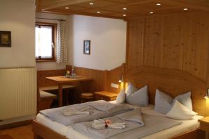 ein Schlafzimmer mit einem großen Bett und einer Holzwand in der Unterkunft Pension Schusterpeter in Bad Tölz