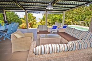 a patio with wicker furniture and a swimming pool at Villa Antema in Riambel