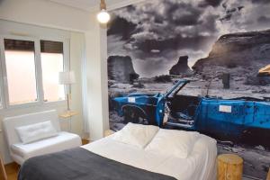 a bedroom with a bed and a painting of a truck at Maite Urban Dreams in Barakaldo