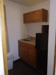 a small kitchen with a sink and a black refrigerator at Hotel Blue Top Inn in Stevens Point