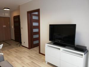 salon z telewizorem z płaskim ekranem na białej komodzie w obiekcie SAS Apartamenty Vega w Szczecinie