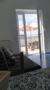 a bedroom with a view of the beach and an umbrella at Citara mare in Ischia