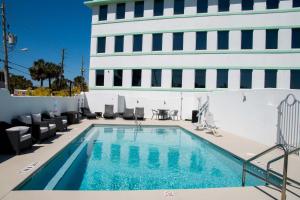 a swimming pool with chairs and a building at The Streamline Hotel - Daytona Beach in Daytona Beach