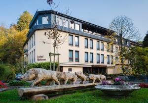 une statue de trois moutons devant un bâtiment dans l'établissement Hotel Brimer, à Grundhof