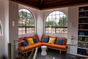 an orange bench in a room with two windows at Sonoma Coast Villa in Bodega