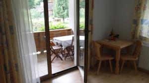 een kamer met een tafel en een balkon met een tafel en stoelen bij Luenerhof in Neustift im Stubaital