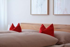 zwei rote Kissen auf dem Bett in der Unterkunft Appartement Karnutsch in Schenna