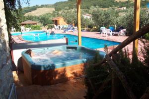 a hot tub in a yard next to a swimming pool at Agriturismo La Casella in San Terenziano +25 photos