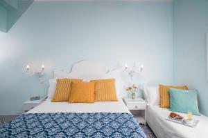 ジャルディーニ・ナクソスにあるオテル ヴィラ ネフェレの青と白のベッドルーム(ベッド1台、ソファ付)
