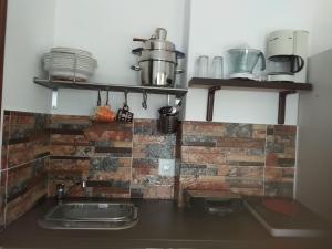 cocina con fregadero y pared de ladrillo en Villa Ateni, en Gavrion