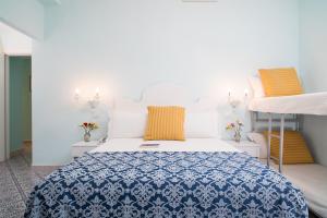 
a bedroom with a white bed and white walls at Hotel Villa Nefele in Giardini Naxos
