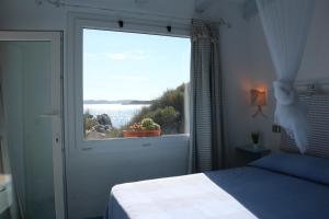 um quarto com uma janela com vista para a água em Lovely Beach House em Conca Verde