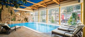 una piscina in una casa con parete di roccia di Hotel Brimer a Grundhof