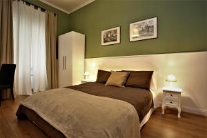 a bedroom with a large bed with green walls at romantica guest house in Rome