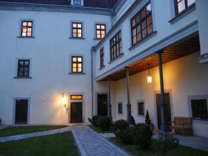 - un grand bâtiment blanc avec une terrasse couverte et une cour dans l'établissement Schloss Gmünd, à Gmünd