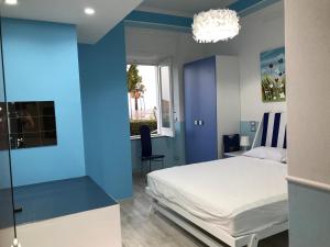 Dormitorio azul con cama y ventana en Villa glory Mare, en Marina di Gioiosa Ionica