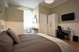 a bedroom with a bed and a desk and a television at romantica guest house in Rome