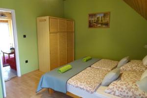 a bedroom with two beds and a green wall at Maxim Ház in Hévíz