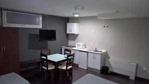 eine kleine Küche mit Tisch und Stühlen in einem Zimmer in der Unterkunft Hostal T4 in Paracuellos de Jarama