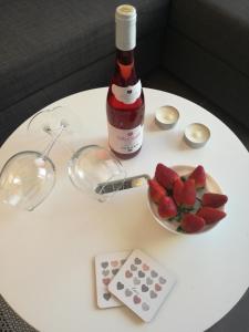 a white table with a bottle of wine and a plate of strawberries at Modern Apartment in Playa del Ingles