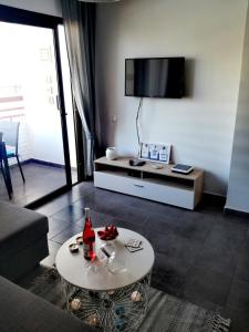 a living room with a table and a tv at Modern Apartment in Playa del Ingles