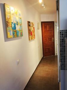 a hallway with paintings on the wall and a door at Modern Apartment in Playa del Ingles