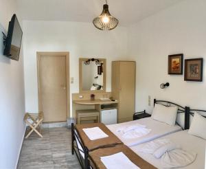 a bedroom with two beds and a desk in it at Platanos Rooms in Anopoli Sfakion